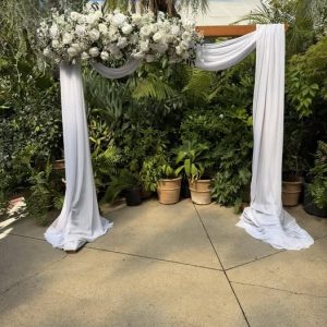 hire wooden arch with draping and artificial flowers